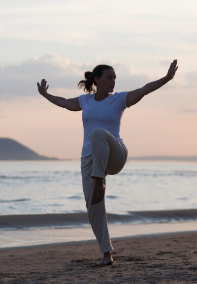 Frau praktiziert Tai Chi am Strand